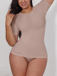 Detail showing high-stretch seamless texture of the nude short sleeve compression top