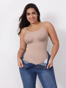 Detailed view of a nude slimming bodysuit with thin straps paired with casual blue jeans