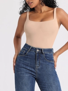 Dettaglio di un body nudo con scollo quadrato abbinato a jeans blu a vita alta