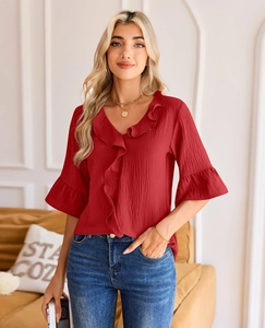 Detail of red V-neck ruffle blouse with pleated texture and stylish lantern flare sleeves