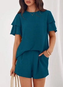 Detail of ruffled sleeves and pleated shorts on dark teal summer two-piece outfit
