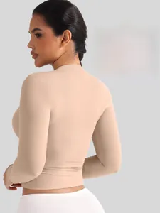 Détail du haut sculptant beige à manches longues montrant le tissu de compression