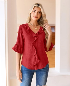 Detailed view of red V-neck blouse with ruffle trim cuffs and vertical fabric texture
