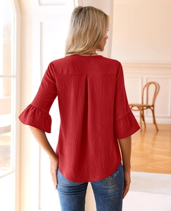 Detail of red lantern sleeve top featuring textured fabric and ruffled bell cuff design
