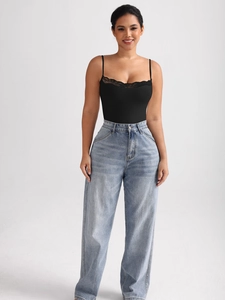 Detail of black lace trim bodysuit paired with light blue high-waisted wide-leg jeans