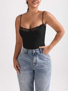 Detail shot of black lace neckline and thin straps on a slim-fit bodysuit with denim jeans