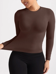 Détail du tissu extensible marron foncé et coupe ajustée du crop top manches longues