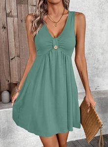 Détail d'une robe verte sauge col en V avec buste froncé et bouton en bois