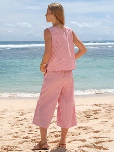 Back view of summer two-piece cotton striped sleeveless top and wide-leg crop pants on beach