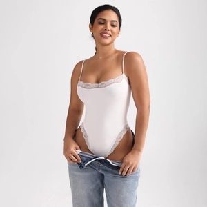Detail of white bodysuit with delicate lace trim and slender shoulder straps