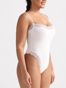 Detail view of the fine white lace trim and thin straps on a slim fit bodysuit
