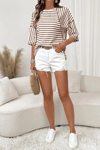 Summer casual outfit featuring a striped t-shirt, white denim shorts, and a straw bag