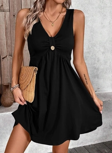Détail d'une robe à col en V avec boutons décoratifs et plis à la taille