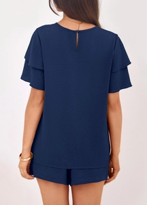 Detail view of navy short set featuring tiered ruffle sleeves and buttoned back keyhole cutout