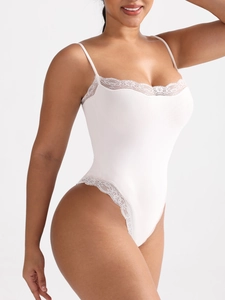 Detailed close-up of white lace bodysuit featuring adjustable straps and sheer eyelash trim