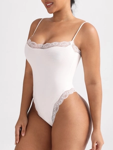 Detail of the white lace trim and thin straps on a sexy high-cut bodysuit for women