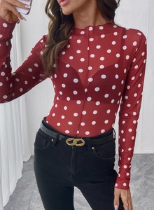 Dettaglio della maglia in mesh rosso semitrasparente a pois bianchi con collo alto