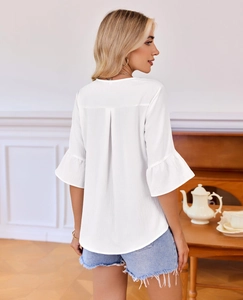 Detail showing back pleated design and ruffled flare sleeves of a white textured blouse