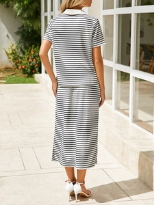 Outdoor shot of the back view of a black and white striped knit 2-piece set with a side slit