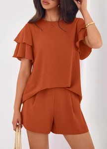 Close-up of burnt orange two-piece set featuring ruffle sleeves and textured fabric
