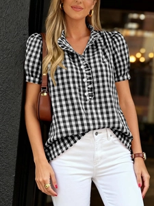 Close-up of women's gingham short sleeve shirt featuring ruffle V-neck and white buttons
