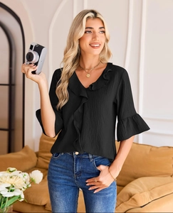 Detail of elegant V-neckline with ruffle trim on a black lantern sleeve casual blouse