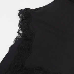Detailed close-up of intricate floral lace trim on a black bodysuit with soft fabric