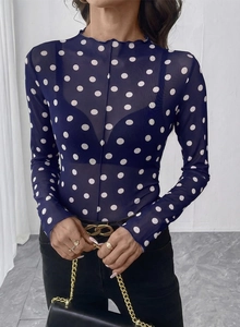 Dettaglio del top in rete a collo alto con pois bianchi su tessuto blu scuro