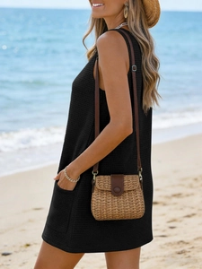 Detail of black waffle knit sleeveless beach dress with side pockets and summer styling