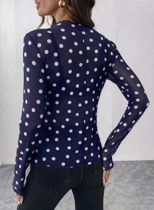 Dettaglio del top in rete blu scuro a pois bianchi che mostra la vista posteriore sul modello