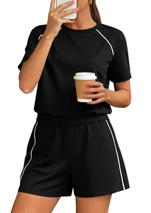 Detail of black sporty two-piece set with white contrast piping and elastic fabric