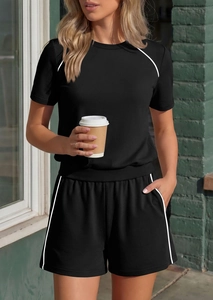 Detail of black sports set featuring white contrast piping on t-shirt and shorts