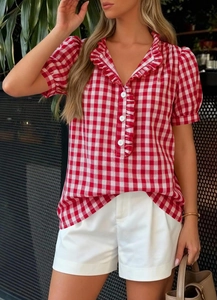 Detail of red gingham short sleeve shirt with ruffle V-neck and white buttons