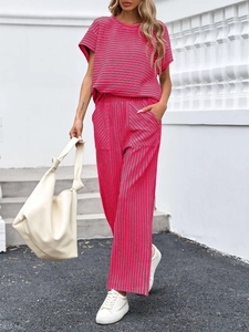 Dettaglio di un set in maglia a righe rosa e grigie con pantaloni larghi e maglietta
