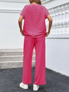 Vista posteriore del completo due pezzi a righe rosa con top a maniche corte e pantaloni larghi