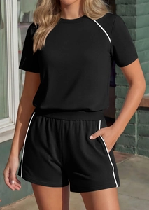 Close-up of black two-piece sports set with crew neck t-shirt and white striped shorts