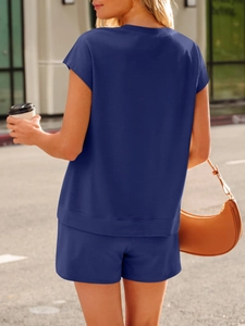 Detail of navy knit two-piece set with V-neck top and elastic shorts on model