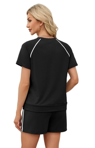 Detail view of black two-piece sports set with contrast white stripes on raglan sleeves
