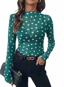 Dettaglio del top verde in mesh trasparente a pois bianchi con collo a lupetto e maniche