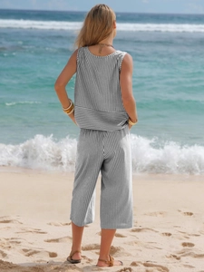 Detail view of cotton striped sleeveless top and wide-leg pants on a sunny beach