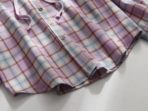 Detail of checkered hooded shirt with purple and blue plaid pattern and button closure
