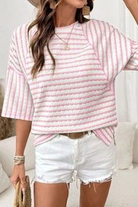 Detailed close-up of pink and white striped textured knit t-shirt with crew neck and stitching