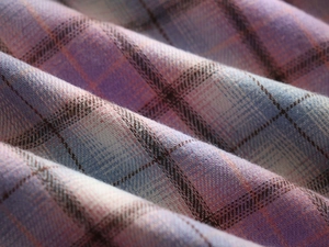 Detailed macro view of purple and blue plaid woven fabric texture for casual hoodies