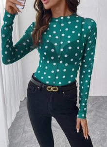 Dettaglio top in mesh trasparente verde con pois bianchi e scollatura con bordo a volant