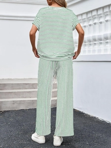 Vista posteriore di un set donna con t-shirt in maglia a righe verdi e bianche e pantaloni larghi