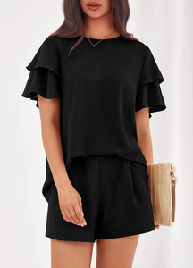 Detail of black summer two-piece lounge set with layered ruffle sleeves and textured fabric