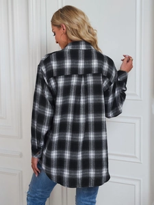Détail du pli d'aisance au dos et coupe ample de la chemise en flanelle à carreaux noirs