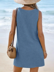 Close-up of blue waffle knit sleeveless beach dress showing texture in seaside setting