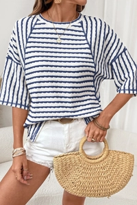 Detail shot of a blue and white striped knit top paired with frayed white denim shorts