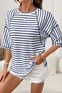 Detail view of women's round neck knit t-shirt featuring blue and white wave textures